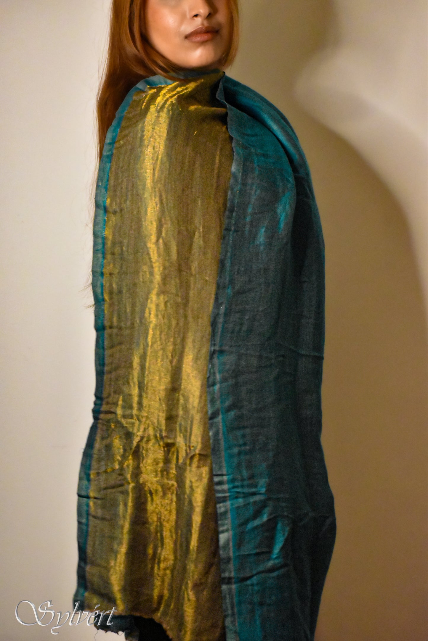 Female Model wearing a teal cashmere with gold silk blended stole from Sylvért's Vissera Collection