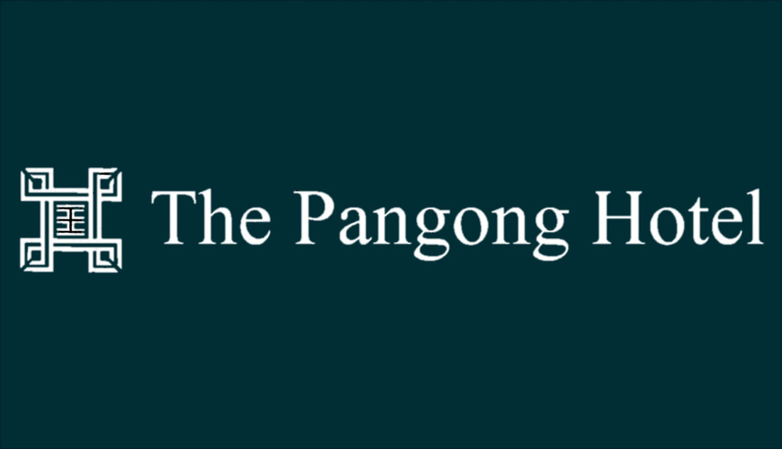 Logo of The Pangong Hotel with decorative emblem on dark background