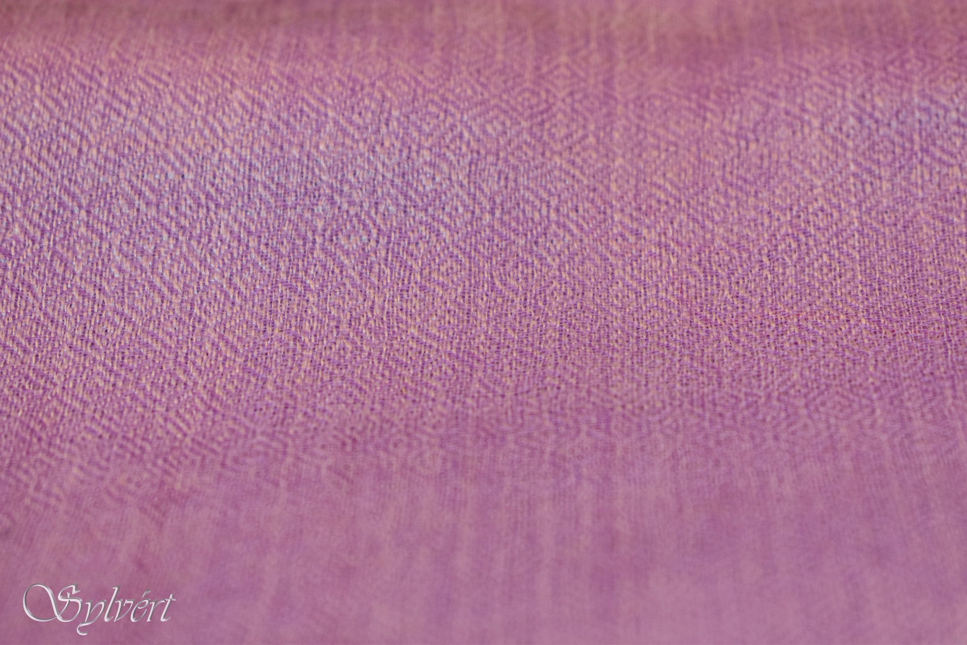 Close-up of lilac fabric texture with intricate embroidered patterns and subtle gradient color