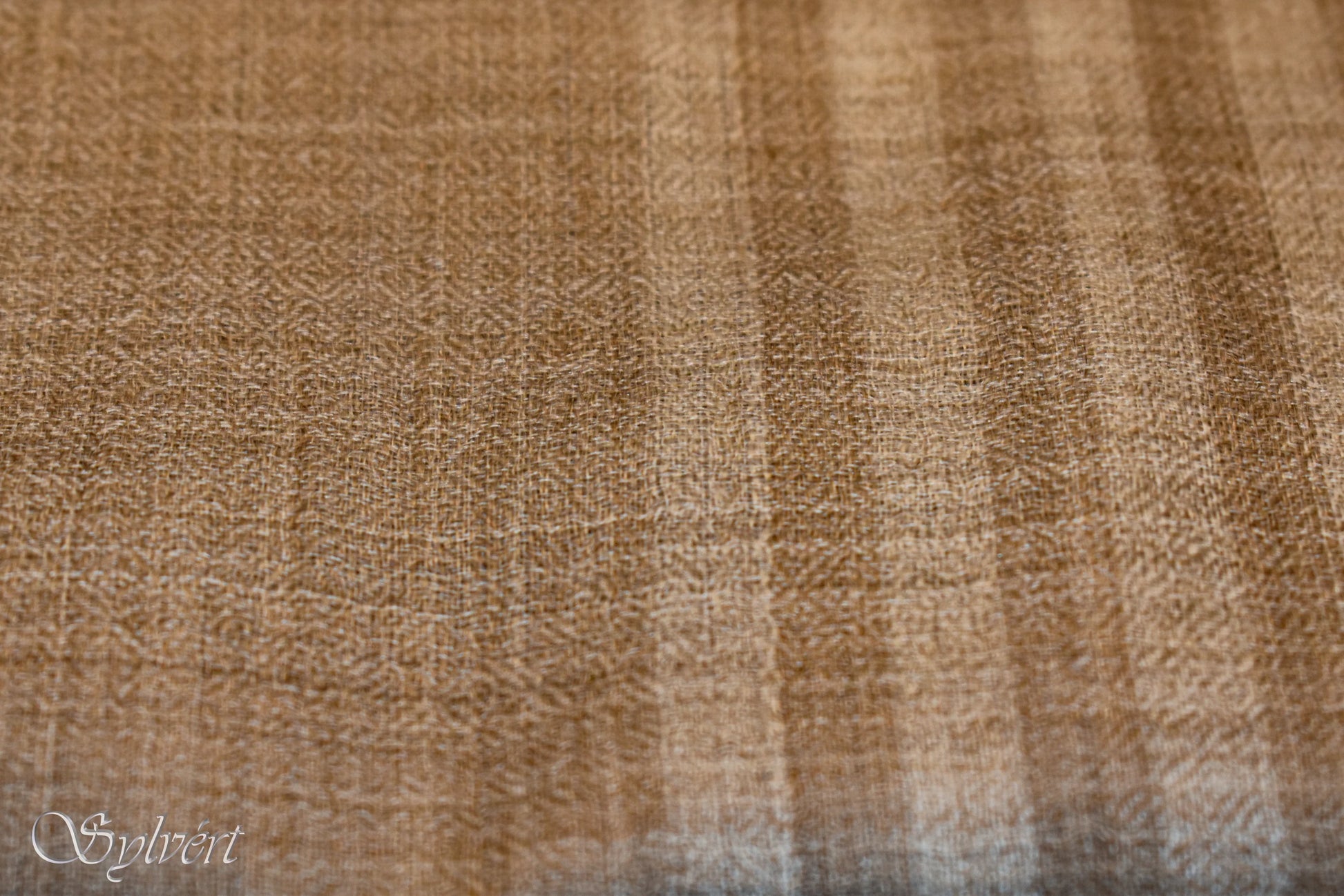 Close-up of sand-colored textured fabric with subtle vertical stripes pattern