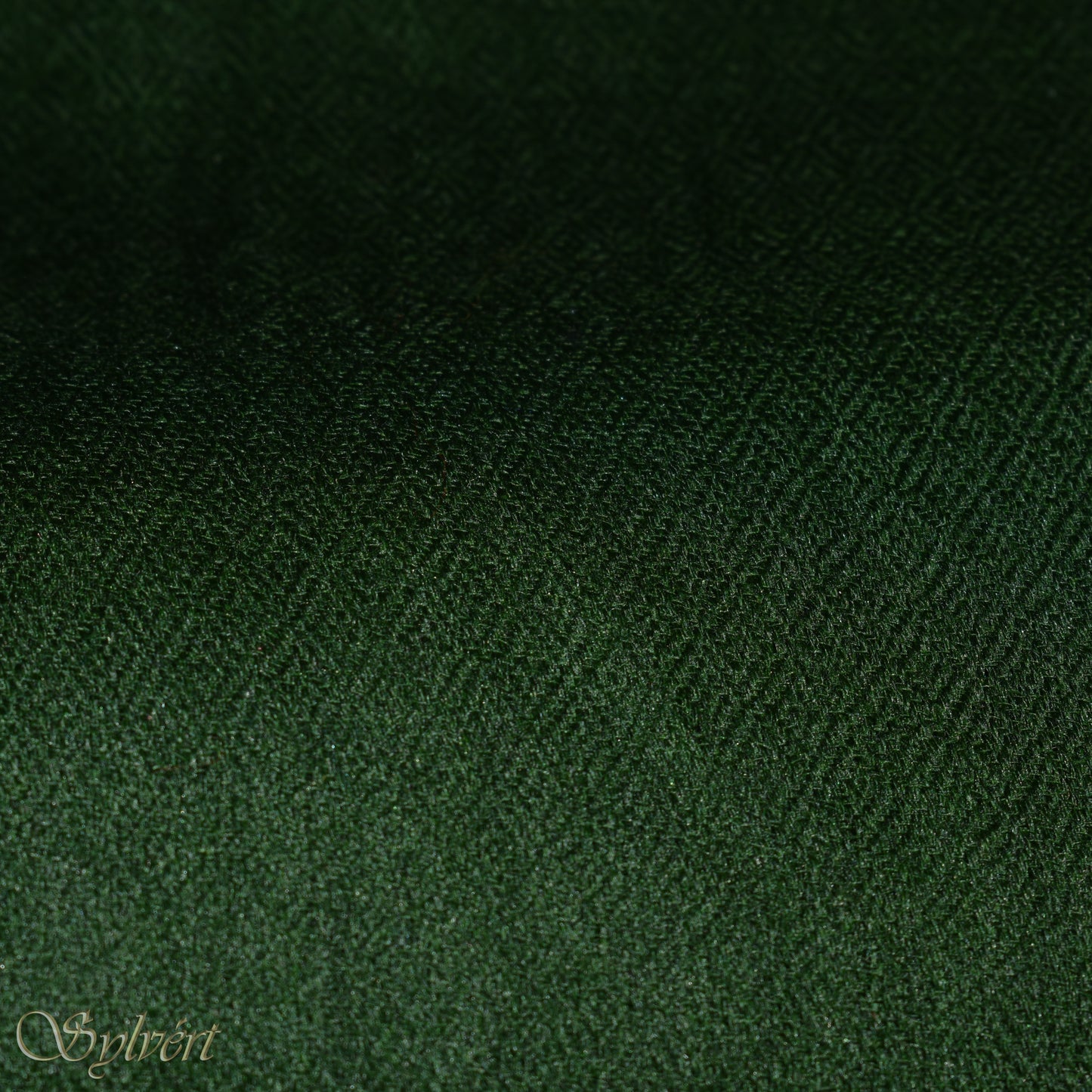 A green cashmere Rivella Tavon Scarf from Sylvért's Rivanor Collection, folded to show the diamond weave texture.