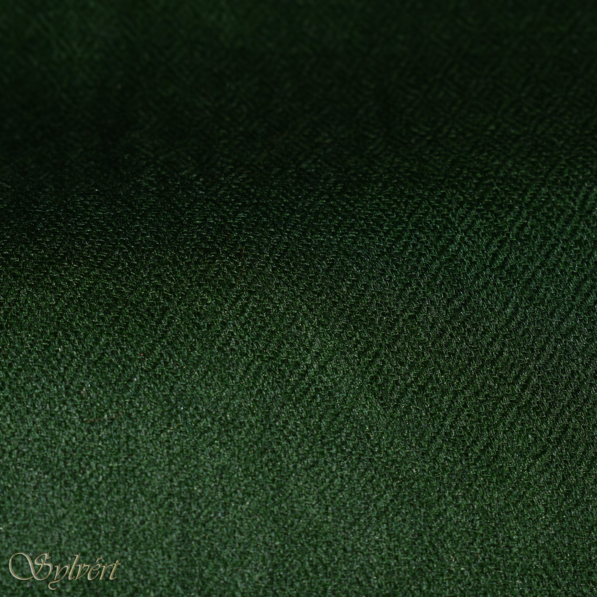 A green cashmere Rivella Tavon Scarf from Sylvért's Rivanor Collection, folded to show the diamond weave texture.