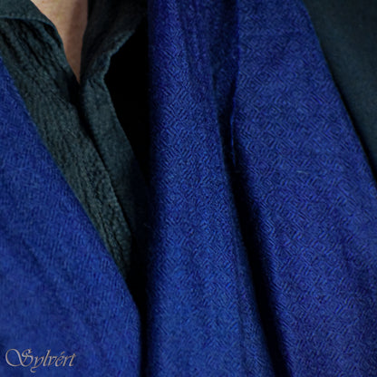 A styled showcase of a blue Corvella Norien from Sylvért's Coronis Collection, worn loosely under a blue jacket