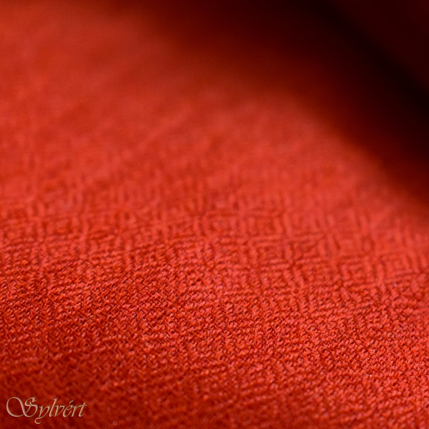 A red cashmere Rivella Sirel Scarf from Sylvért's Rivanor Collection, folded to show the diamond weave texture.