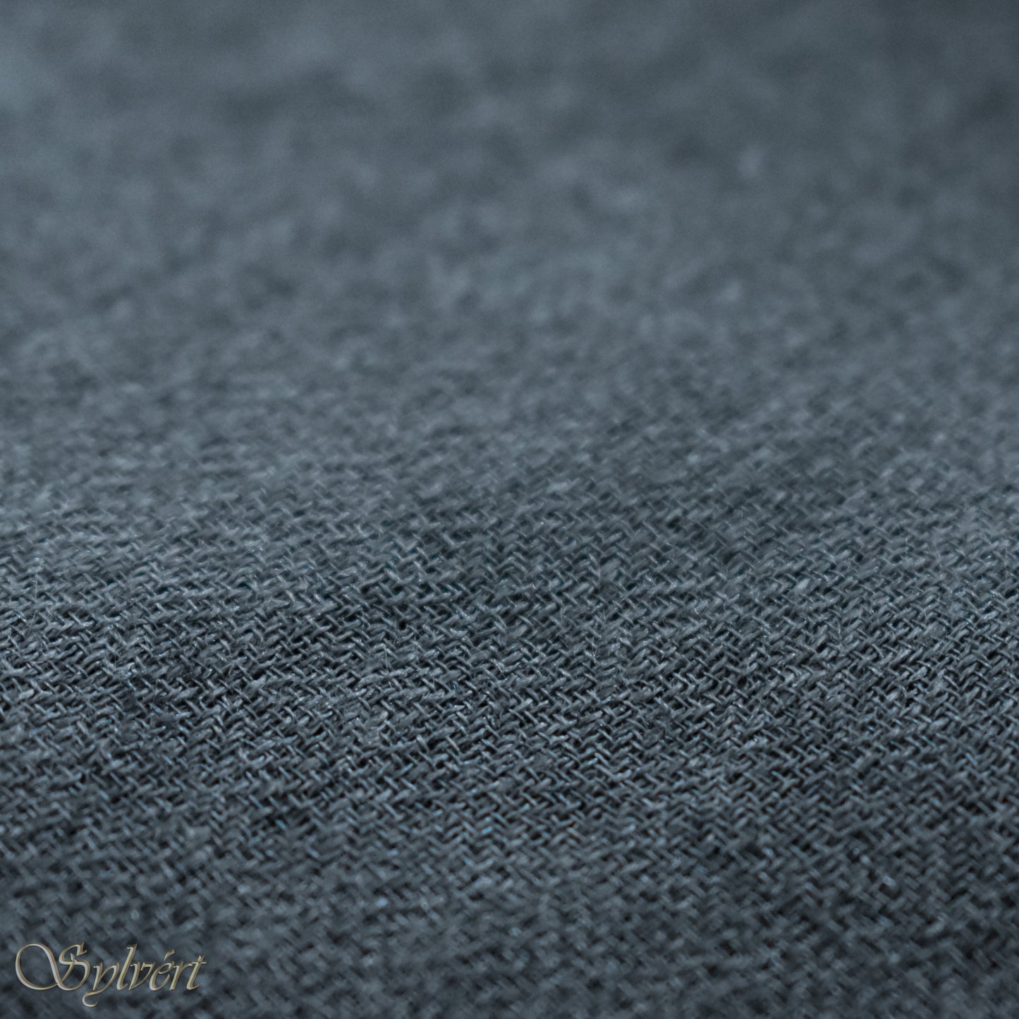 A blue-grey slate cashmere Rivella Veyra Scarf from Sylvért's Rivanor Collection, folded to show the diamond weave texture 