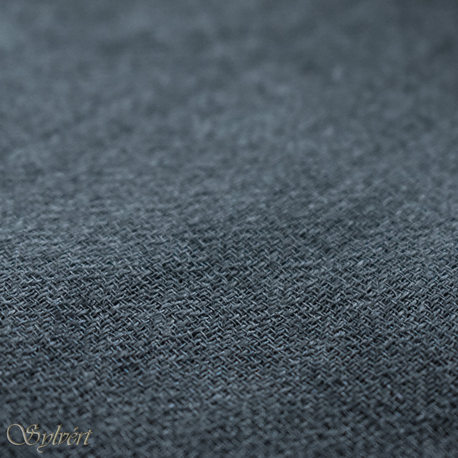 A blue-grey slate cashmere Rivella Veyra Scarf from Sylvért's Rivanor Collection, folded to show the diamond weave texture 