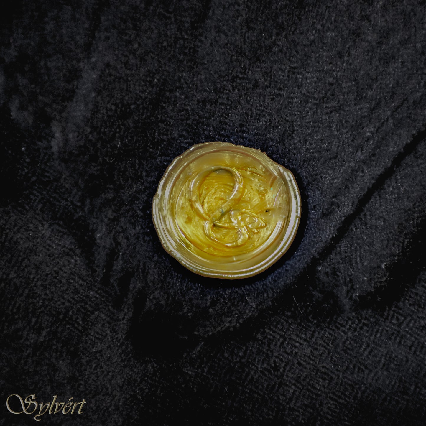 A black Corvella Noctra from Sylvért's Coronis collection, folded to show the diamond weave texture  and gold Sylvért stamp