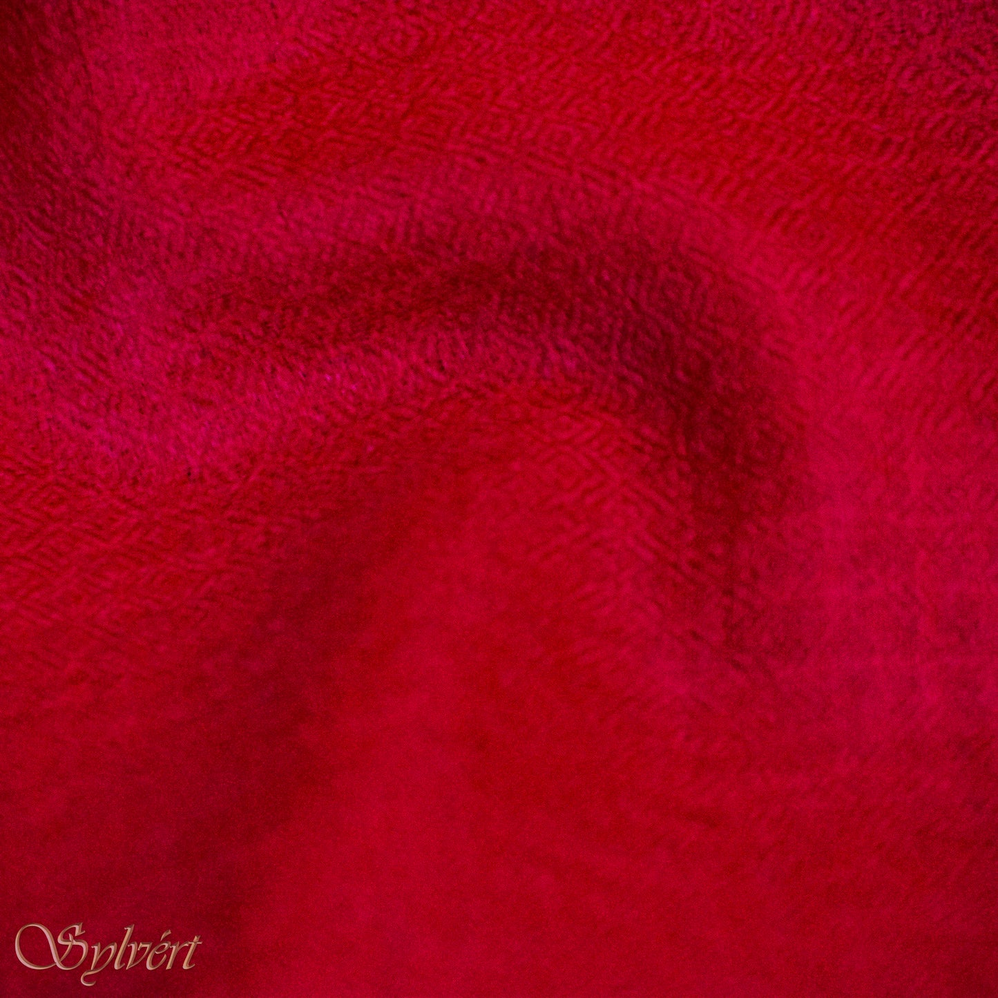 A red Corvella Sorell from Sylvért's Coronis collection, folded to show the diamond weave texture 