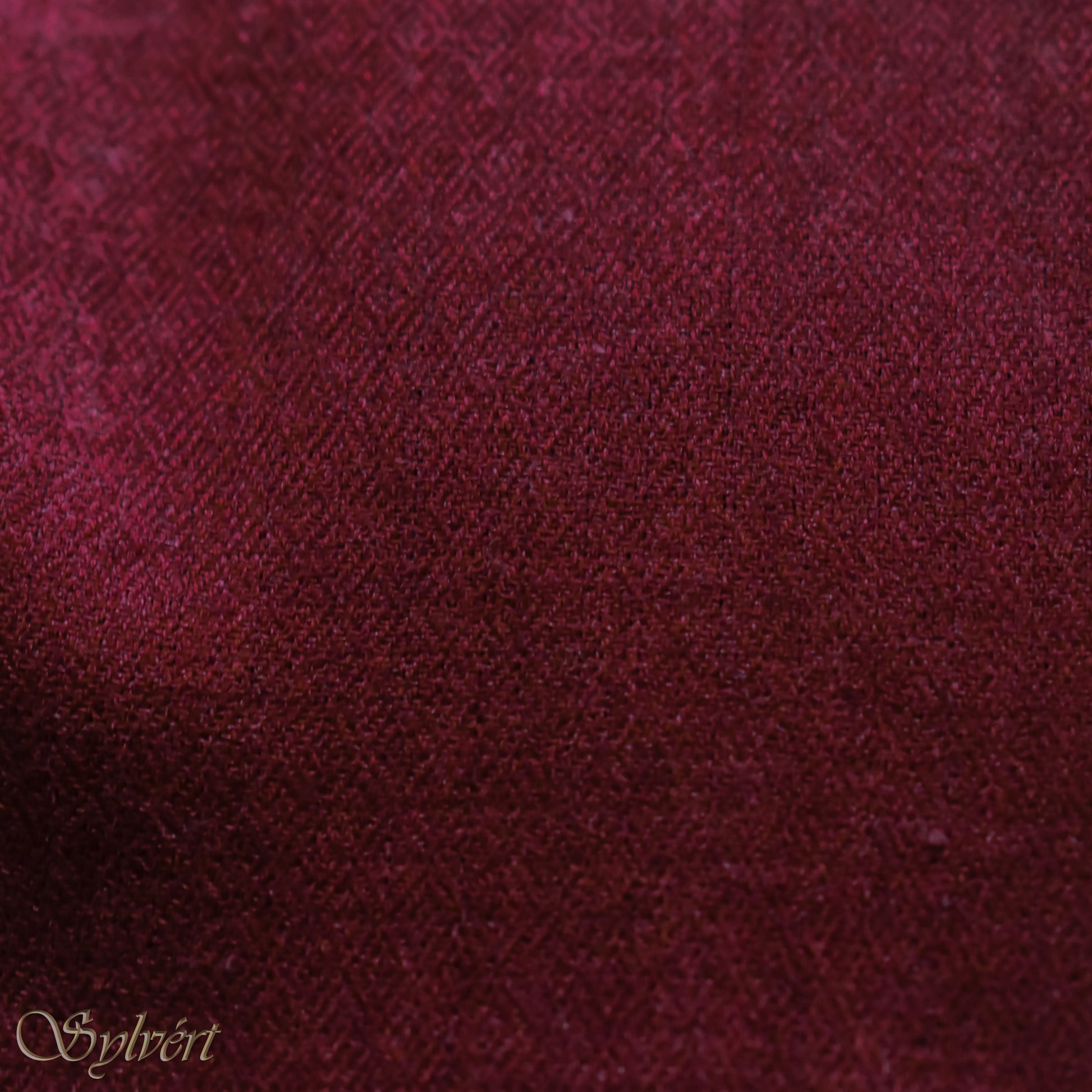 A maroon cashmere Rivella Morven Scarf from Sylvért's Rivanor Collection, folded to show the diamond weave texture