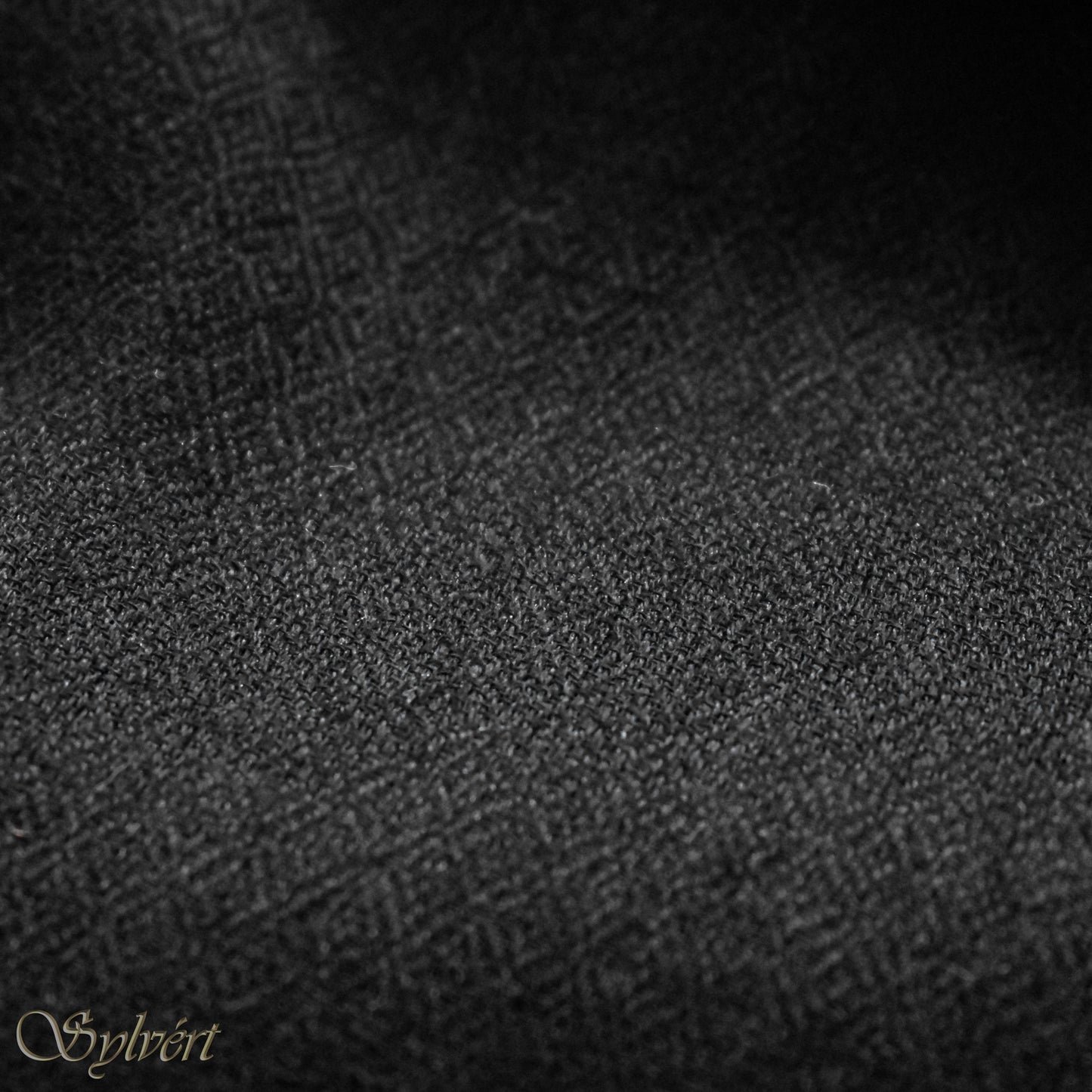 A black cashmere Rivella Velin Scarf from Sylvért's Rivanor Collection, folded to show the diamond weave texture