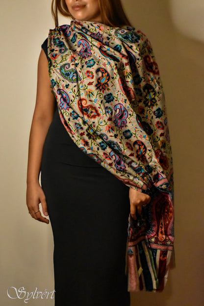 Woman in black dress wearing colorful paisley pattern shawl with fringe